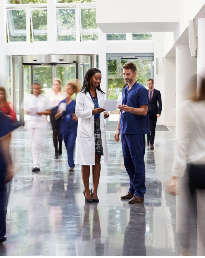 Healthcare professionals discussing basic insurance in a Swiss hospital lobby