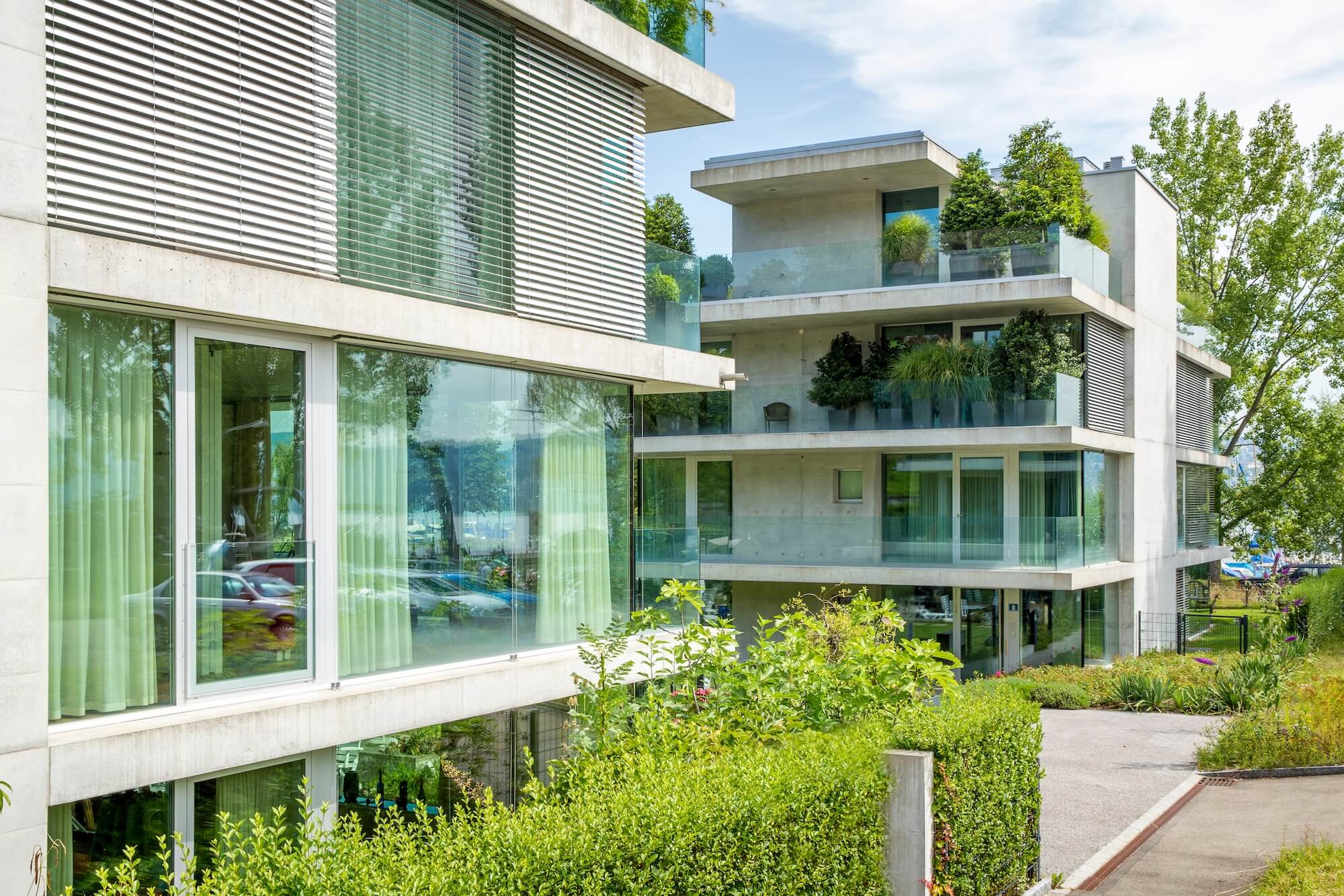 Immeuble résidentiel suisse moderne avec balcons vitrés et verdure